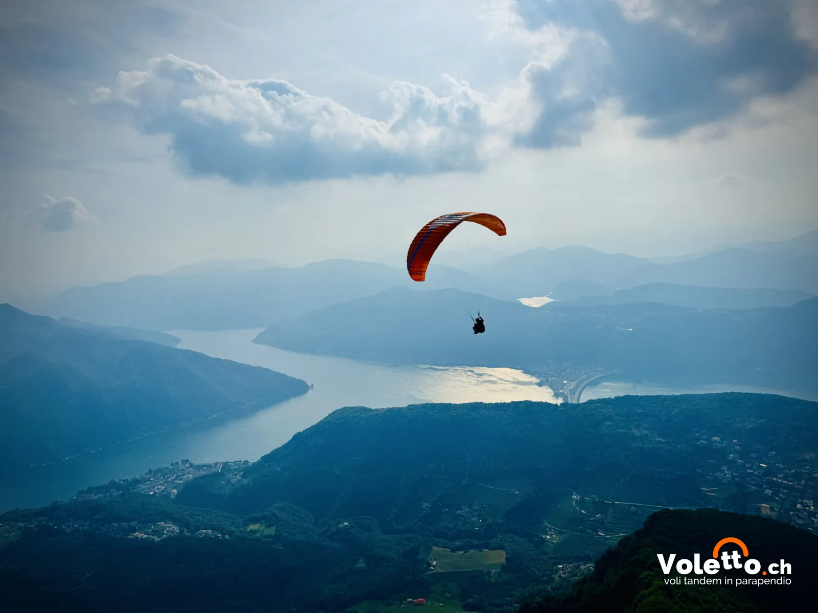 Parapendio in volo sopra il Lago di Lugano verso Melide