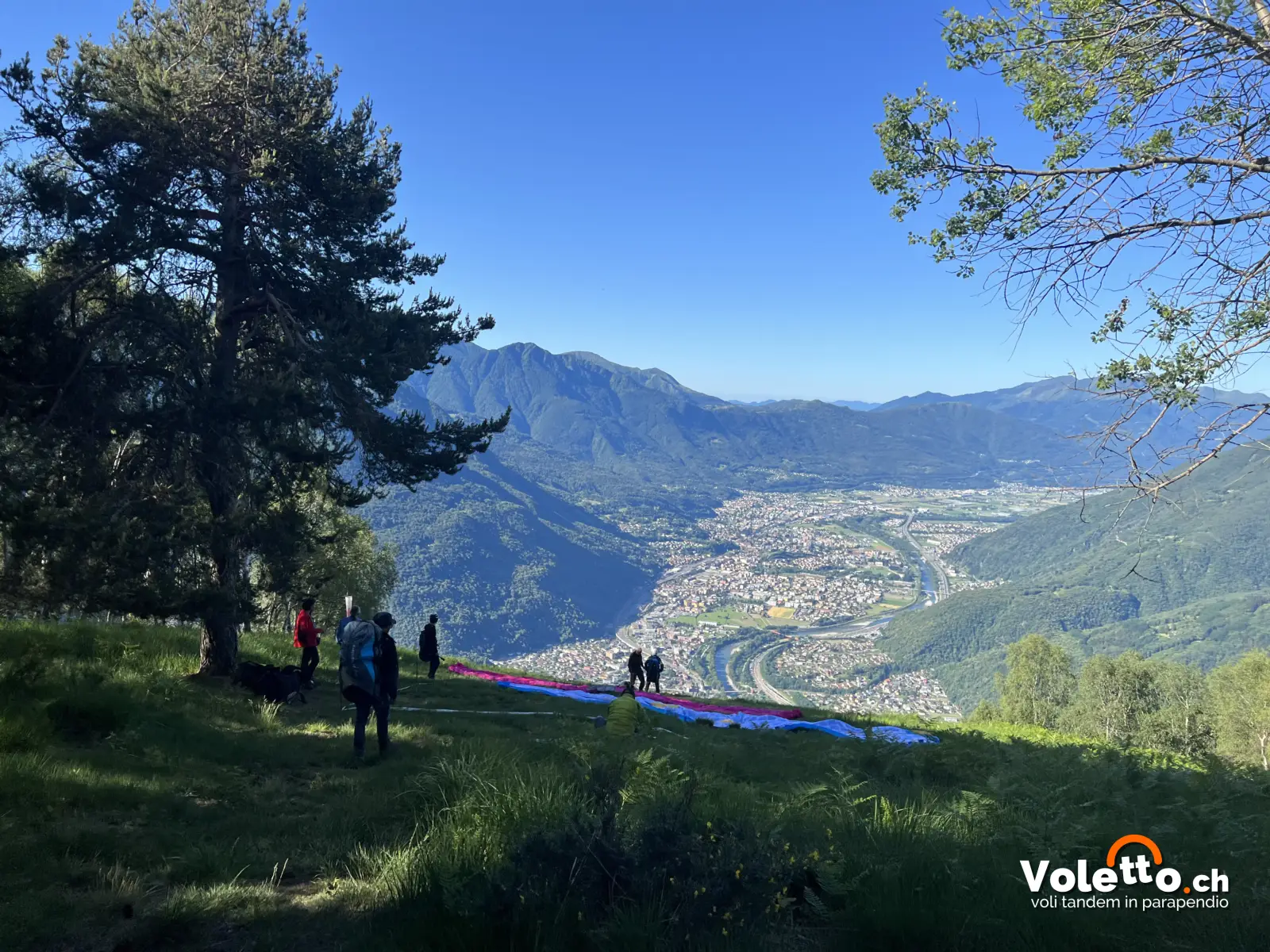 Piloti al decollo di Parusciana con il panorama del Bellinzonese